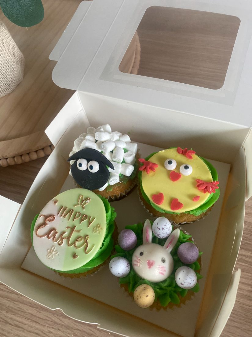 Box of four Easter cupcakes with a bunny, a chick and a sheep