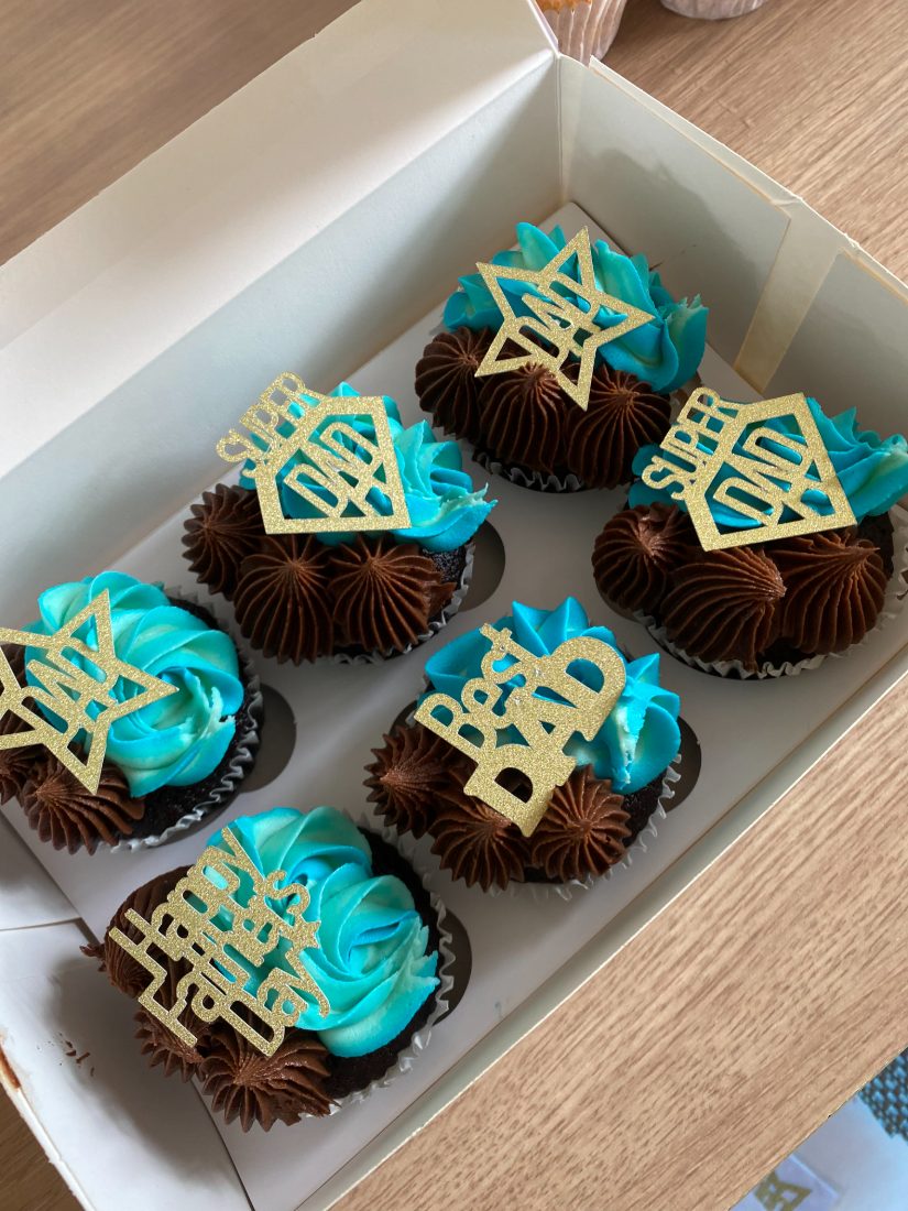 Chocolate cupcakes with blue swirls and gold Dad toppers