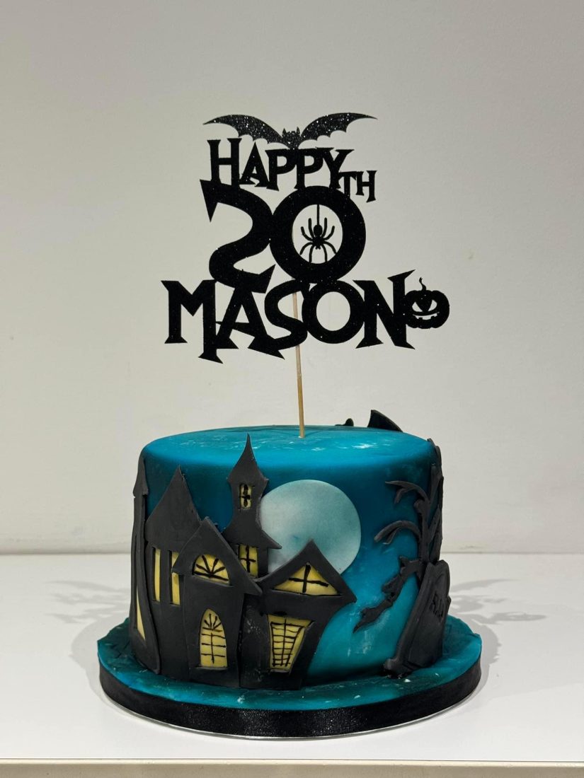 Teal Halloween cake with a black haunted house silhouette